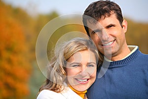 The husband embraces wife in autumn park