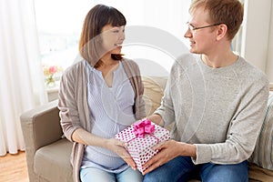 Husband giving birthday present to pregnant wife