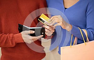 Husband Giving Credit Card To Wife Shopping In Mall, Cropped