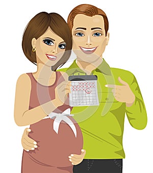 Husband and his pregnant wife pointing to calendar