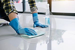 Husband housekeeping and cleaning concept, Happy young man in blue rubber gloves wiping dust using a spray and a duster while