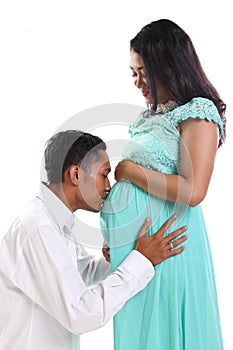 Husband kissing her pregnant wife& x27;s belly