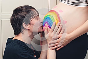 Husband kissing newborn through wife belly. Future dad kissing belly of his pregnant wife. Man kissing stomach, pregnant woman,