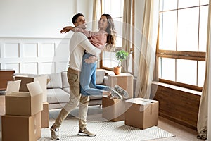 Husband lifts up wife celebrating relocation day to new house