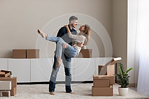 Husband lifts wife on arms celebrate together relocation day