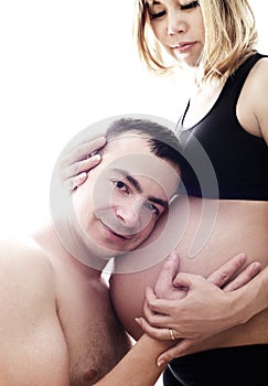 Husband listening the belly of his pregnant asian wife isolated on white background