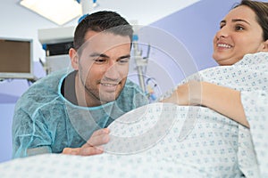 Husband looking lovingly at wifes bump during childbirth