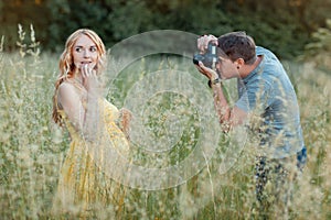 Husband photographs the pregnant wife in a field