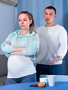 Husband and pregnant wife arguing at home