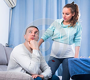 Husband and pregnant wife arguing at home