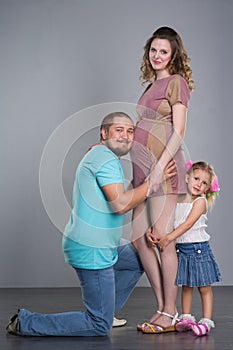 Husband and pregnant wife with a child