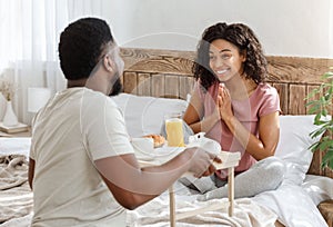 Husband surprising wife with breakfast in bed