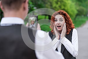 Husband takes pictures of his redhead wife and she poses.