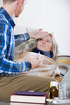 Husband taking care of young wife with flue at home