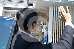 Husband waving goodbye to his family before going to work