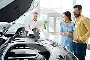 Husband and wife choose a car at a car dealership