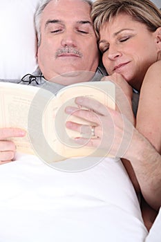Husband and wife cuddling in bed