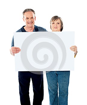 Husband and wife displaying advertising board