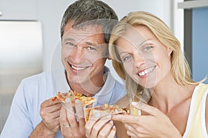 Husband And Wife Eating Pizza