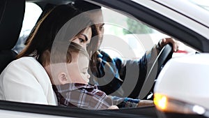 A husband, wife and little son are sitting in a new car. The joy of a new purchase.