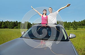 Husband, wife pose in hatch of car