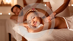 Husband And Wife Receiving Back Massage Relaxing Lying At Spa