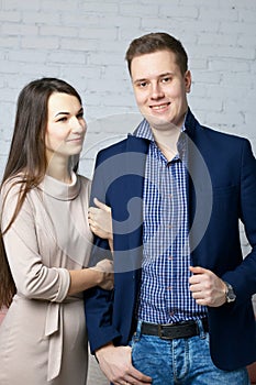 Husband and wife on the set in the studio. The wife with tenderness holds her husband`s arm. A husband with a pleased look is