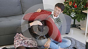 Husband and wife smile and laugh enjoying funny fighting with pillows