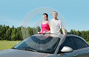 Husband, wife stand in hatch of car
