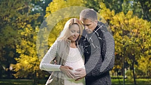 Husband and wife stroking pregnant belly, waiting for newborn baby, parenting