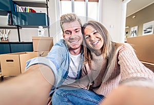 Husband and wife take a selfie moving in new home - Young couple just moved into new apartment