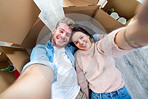 Husband and wife take a selfie moving in new home - Young couple just moved into new apartment