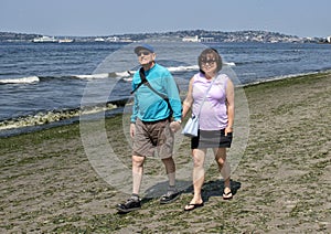 Husband and wife on vacation enjoying a walk on Alki Beach, Seattle, Washington