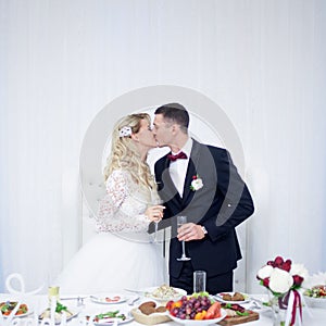 Husband and wife at the wedding, Banquet table, kiss