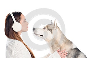 husky dog and beautiful woman in winter earmuffs