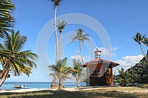 Hut or Cottage on the coconut beach. The clock tower or lifeguard tower against the blue sky