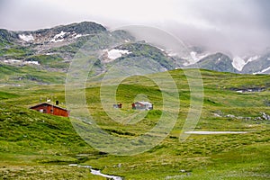 Hut wooden mountain huts in mountain pass Norway. Norwegian landscape with typical scandinavian grass roof houses. Mountain