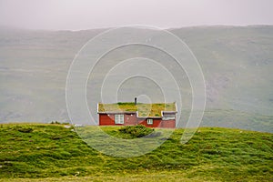 Hut wooden mountain huts in mountain pass Norway. Norwegian landscape with typical scandinavian grass roof houses. Mountain