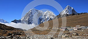 Huts in Lobuche and snow covered mountains Tobuche, Taboche and Cholatse photo