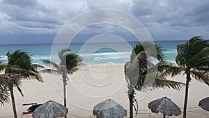 Huts and palm trees on tropical sandy beach at Cancun city of quintana roo in Mexico, seaside of Caribbean Sea.