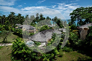 Huts village beside the sea and tropical environment with the cloudy sky