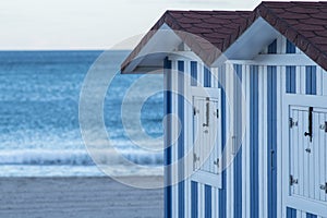 Huts with white and blue strips on the beach