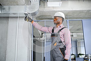 hvac african worker install ducted pipe system for ventilation and air conditioning. copy space