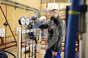 HVAC engineer in boiler room monitoring pressure gauges