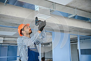 hvac indian worker install ducted pipe system for ventilation and air conditioning. copy space