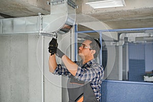 hvac indian worker install ducted pipe system for ventilation and air conditioning. copy space