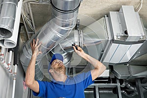 Hvac services - worker install ducted pipe system for ventilation and air conditioning