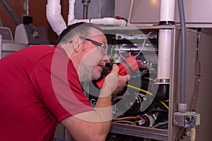 HVAC Tech Inspecting A Gas Furnace
