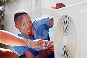 HVAC technician installing air conditioner