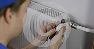 Hvac technician installing home central heating radiator thermostat valve